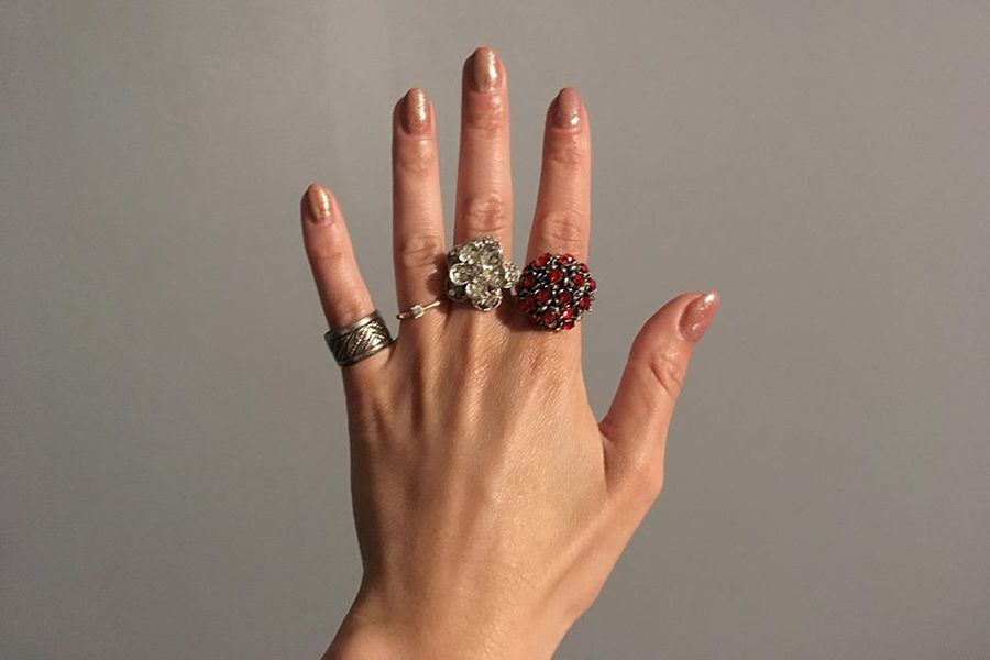 Pierścionki o różnym rozmiarze, kształcie i kolorze na palcach kobiecej dłoni